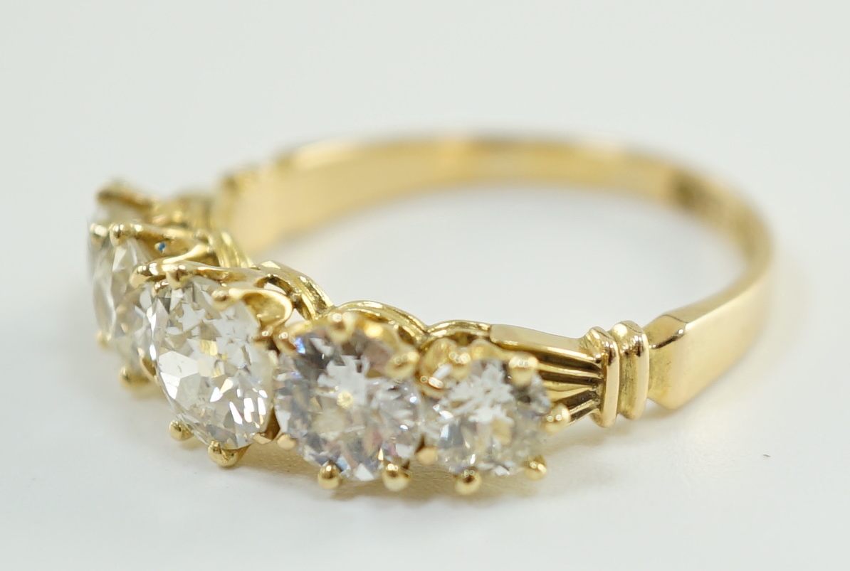 An 18ct gold and graduated five stone diamond set half hoop ring